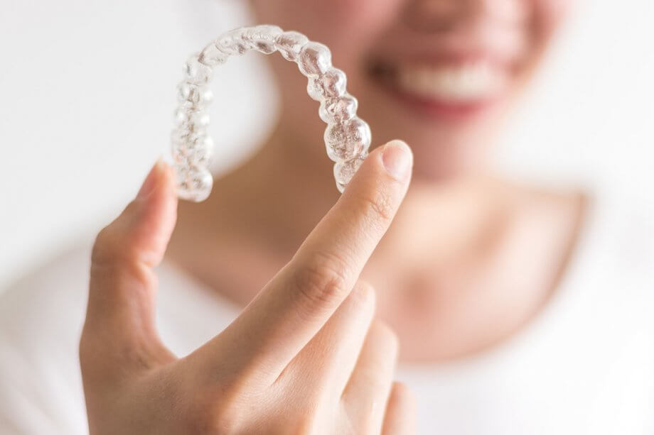 woman holding Invisalign appliance in hand