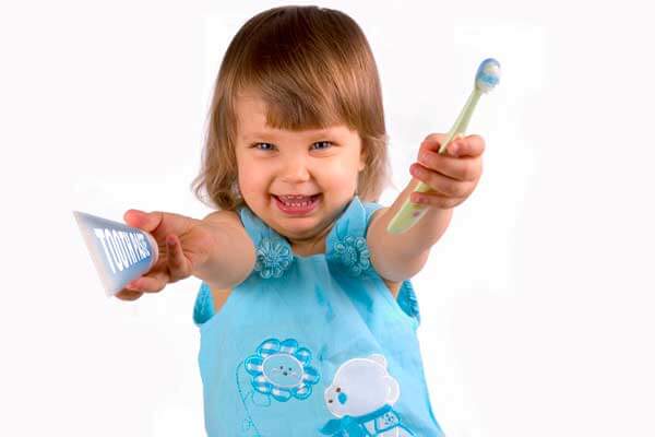 Little Girl Holding Toothbrush and Toothpaste